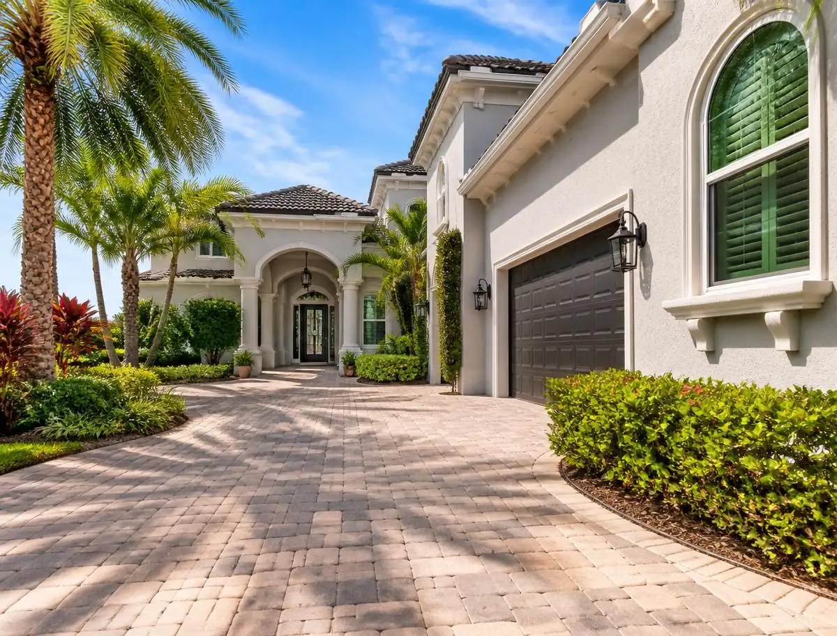 Freshly pressure washed stucco Florida home with paver driveway and palm trees